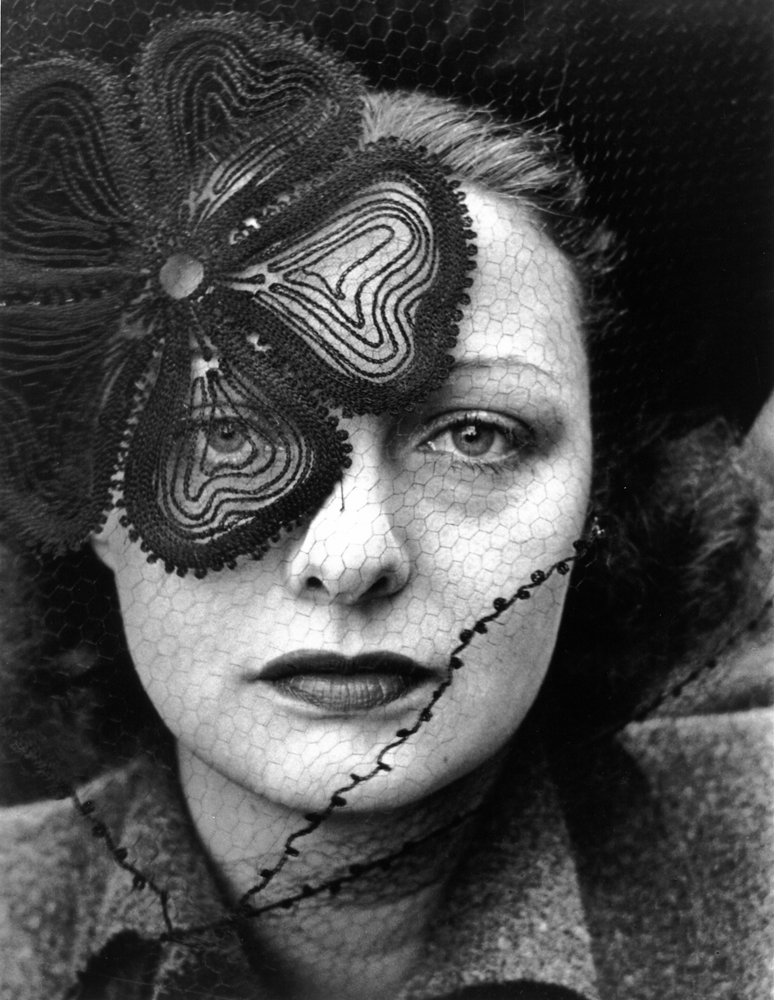 Model Janet MacLeod wearing a veiled hat designed by Lilly DachÂŽ, 1937.
